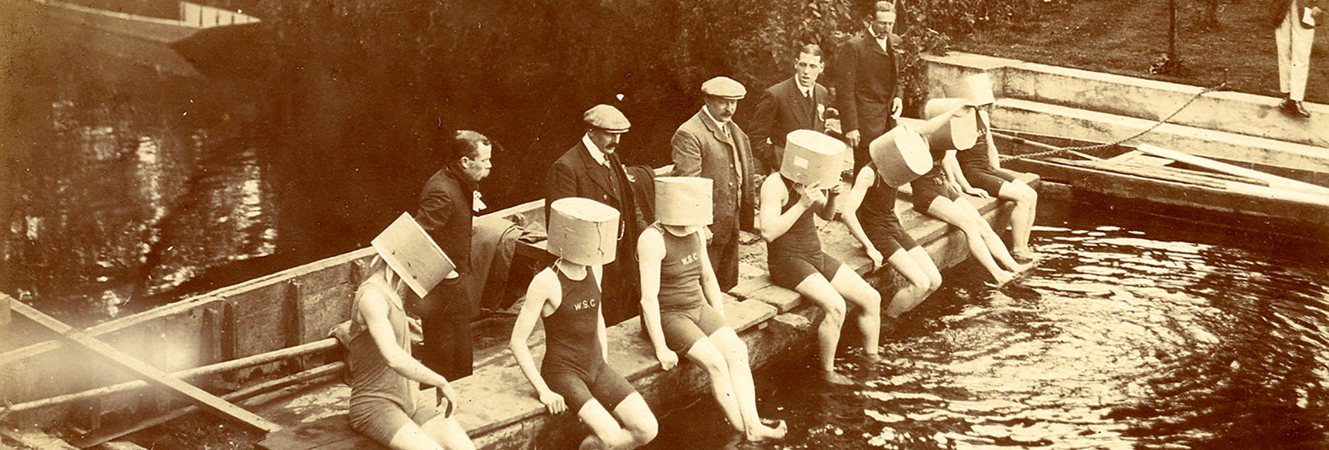 Swimmers sit with buckets on their heads c.1910 ref. WI/D194/1