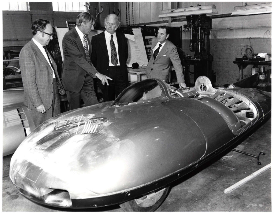Four men stand around a world land speed record car c.1950s ref. D/SG10/8/41/2