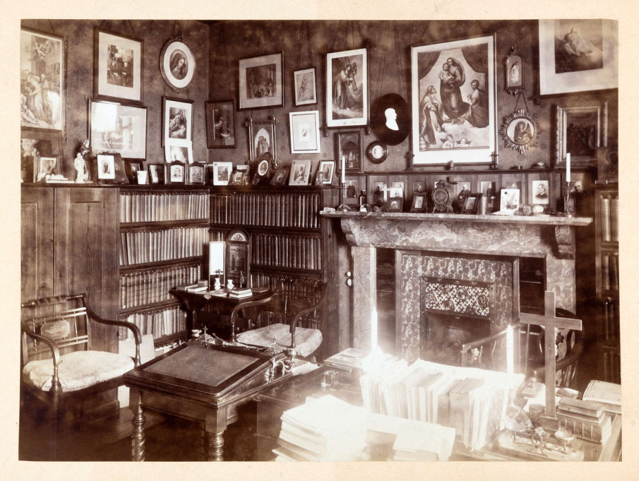 Room with fireplace, pictures on the wall, table with itemm upon it in Canon Carter's study nineteenth century ref. D/EX1675/1/22/97