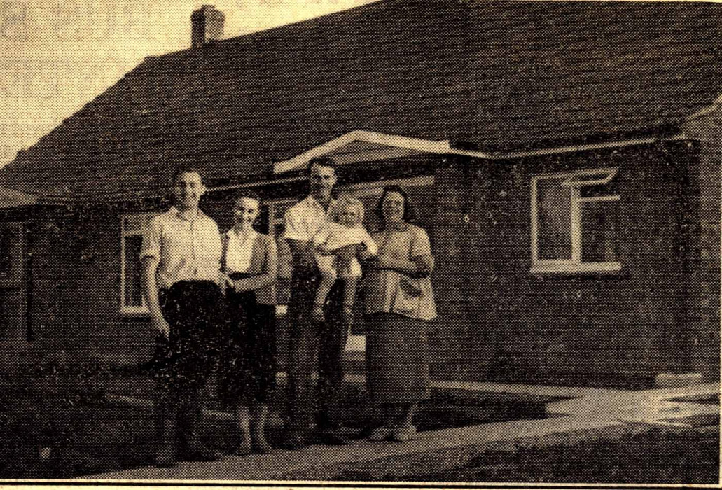Families stand outside a newly built house from the Windsor, Slough and Eton Express D/EX2844
