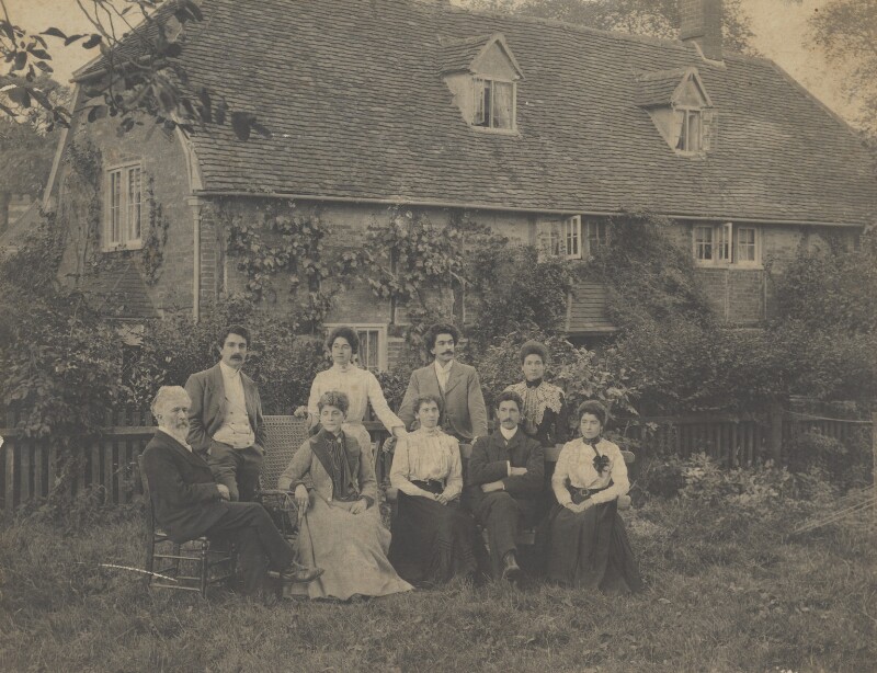 A group of people stood and sat together in front of a house. NPG x199822 © National Portrait Gallery, London. Reproduced under Creative Commons License.