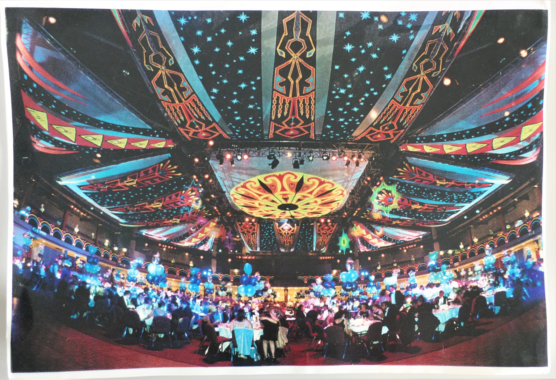 Colour photograph of a corporate party with drapes painted with ultraviolet paint on the ceiling