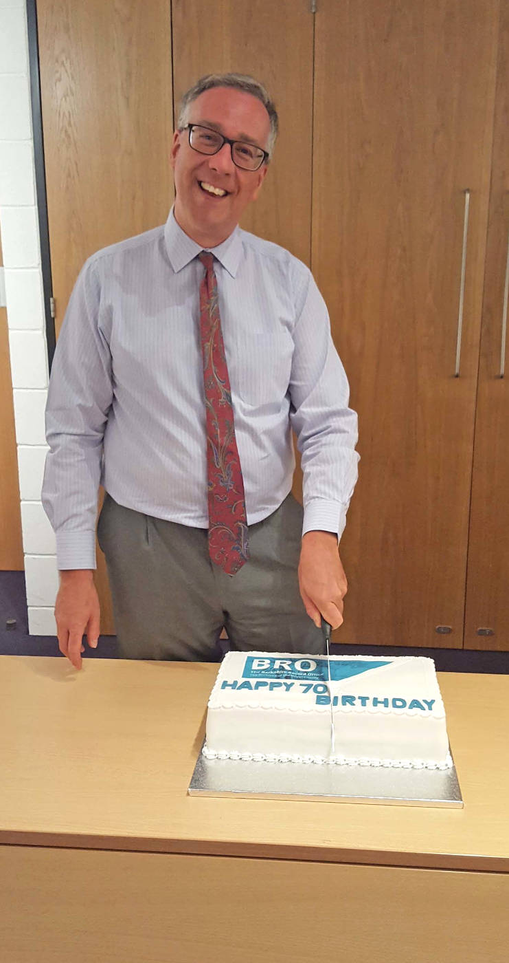Mark Stevens current County Archivist of the Royal Berkshire Archive cutting a 70th birthday cake in 2018.